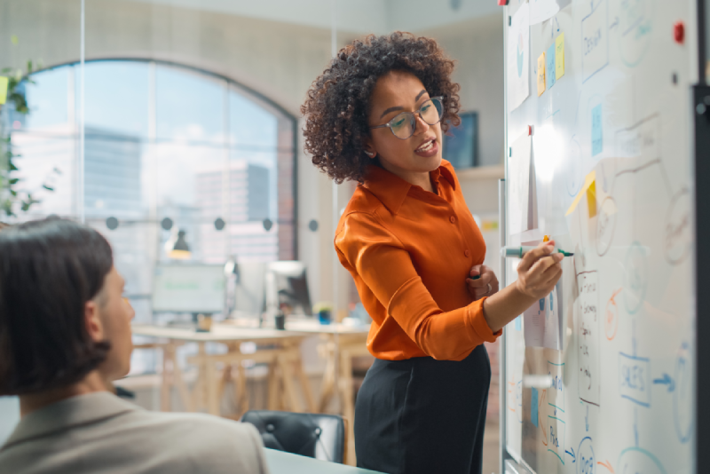 Female leader discussing a leadership development strategy on a whiteboard